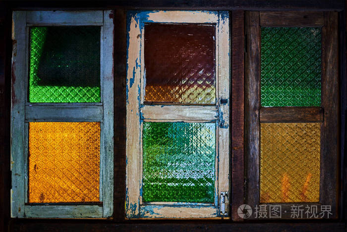 旧的木制窗户, 颜色为彩色玻璃.彩色玻璃窗在木制破旧的框架.