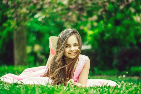 在与花瓣互生的绿色草地上的小女孩