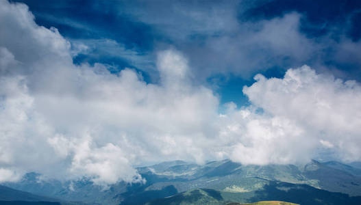美丽的景色 Chornohora 山脊和美丽的多云天空从斜坡 Hoverla 山。风景秀丽的雾中长青针叶树低卧云中的山坡