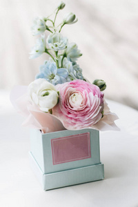 美丽的春天花束与嫩粉红色石龙芮花在箱子, 典雅的花卉装饰