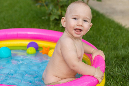 一个小孩子在游泳池里洗澡, 夏天充气儿童充气池。
