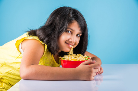 快乐的亚洲孩子吃美味的面条小印度女孩