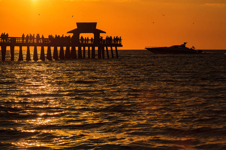 美丽的日落沿那不勒斯海滩码头与游艇巡航在那不勒斯, 佛罗里达州
