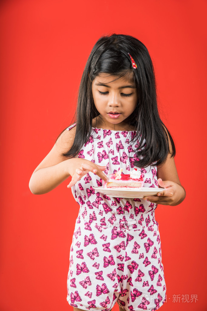 印度孩子的肖像吃蛋糕或糕点, 可爱的小女孩吃蛋糕, 女孩吃草莓蛋糕在