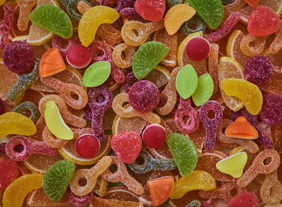各种彩色胶粘糖果作为背景, 顶部视图。七彩鲜艳的各式糖果和彩虹果冻甜美。各式各样的五颜六色的果冻和糖糖果。顶部视图。糖果背景