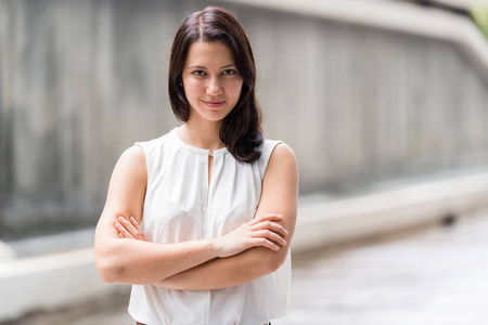 美丽的年轻女子的肖像在户外双臂交叉