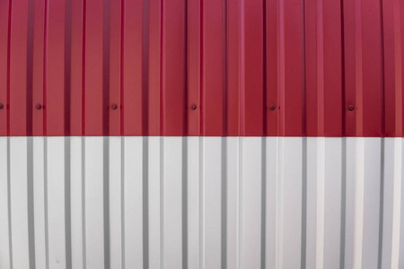 工业建筑和建筑用金属白色和红色板材。工厂大厦或仓库的屋顶金属板或波纹屋顶
