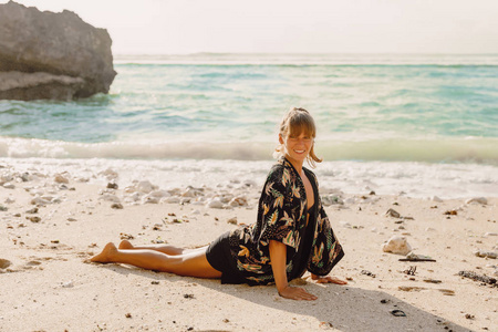 年轻健康的妇女在黑色运动服练习瑜伽, 而站在 Bhujangasana 海岸