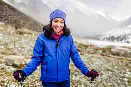 山中徒步旅行的年轻女人。其雪，阳光灿烂，早春