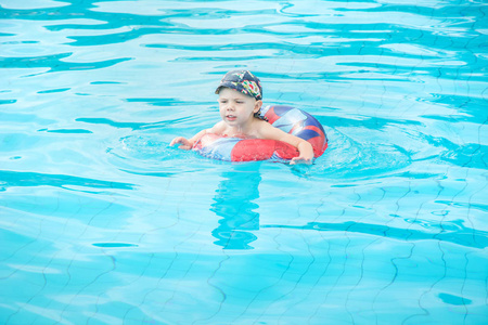 小男孩游泳, 欢快的孩子跳在池塘里的圆形, 露天游泳池