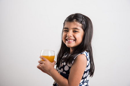 印度的小女孩在一杯喝芒果汁或冷饮料或果汁