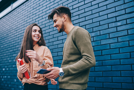 男女学生交谈, 而男人注意到联系的数字漂亮的女孩, 情侣相爱沟通和