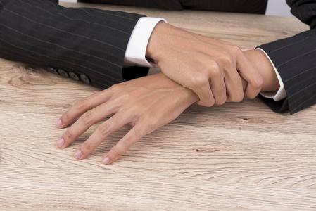 那个女人把胳膊放在桌子上, 抓住了她的手指.照片