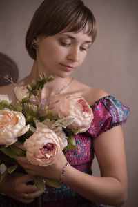 一个年轻女子的肖像在老式礼服。投在演播室在一个平的背景
