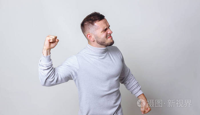 白人男子举起拳头在灰色背景复制空间的战斗姿态