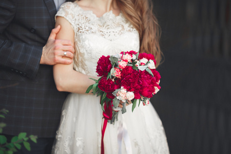 新婚夫妇拥抱，她手里拿着一束鲜花，新娘，新郎拥抱