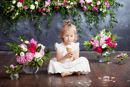 小女孩吃冰淇淋。室内的花朵装饰。可爱女孩的画像