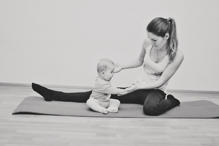 年轻的母亲和她的 bab 锻炼瑜伽
