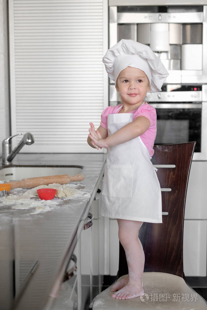 漂亮的小女孩学会在厨房里做饭