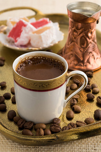 老式杯土耳其咖啡和土耳其美食在青铜托盘上的天然席子服务