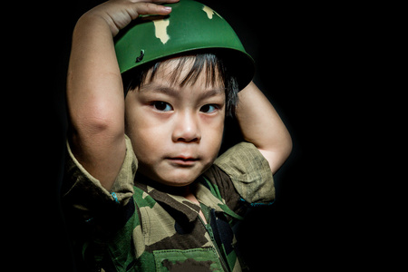 年轻的亚洲男孩穿得像一名士兵