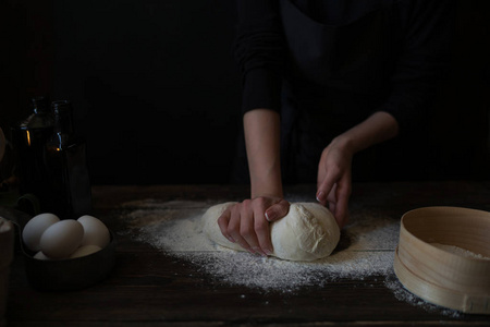 贝克捏面团的看法。自制的面包。手在木桌上准备面包面团。准备传统的自制面包。女人手揉捏新鲜面团做面包