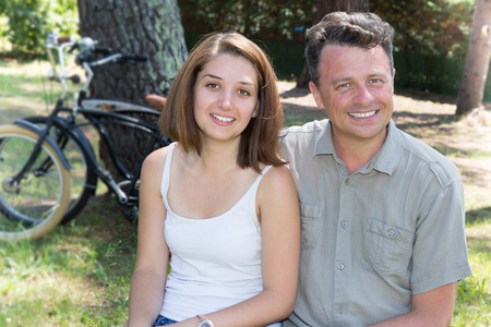 年轻夫妇在骑自行车，在阳光明媚的一天在森林里