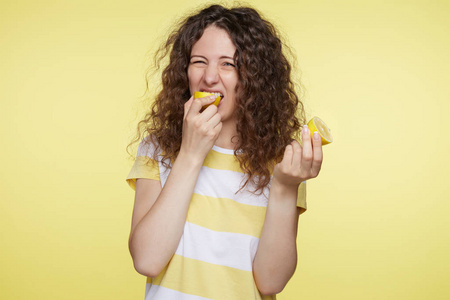 水果的味道可爱的白种女性的肖像与令人作呕的表情味道酸柠檬, 皱眉在