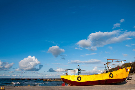黄色的渔船停泊在沙滩上