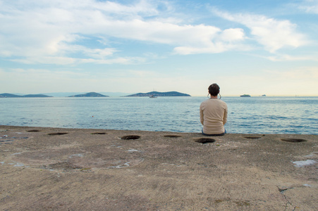 年轻人坐在大海边图片