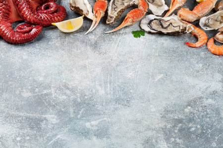 海鲜.章鱼, 牡蛎, 龙虾, 虾, 蛤蜊烹饪。带空格的石桌上的顶部视图