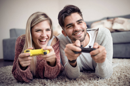 微笑情侣在他们的客厅里玩视频游戏