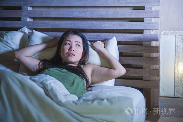 年轻美丽沮丧和悲伤的中国女性的生活方式晚上躺在床上失眠无眠焦虑