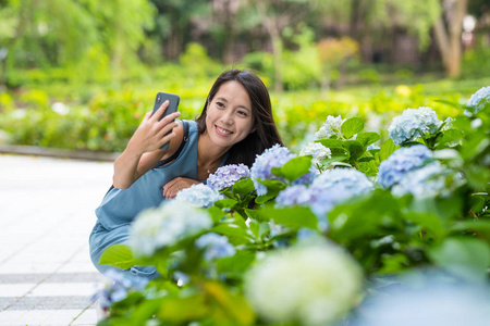 在绣球花农场用手机自拍的女人