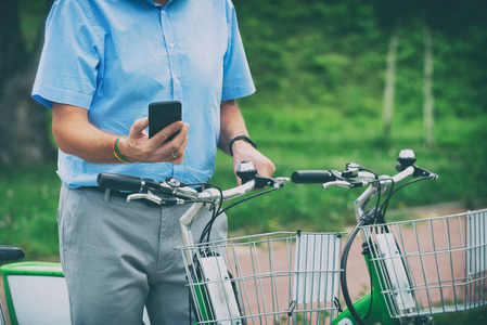 男子使用智能手机租用自行车从城市自行车共享站