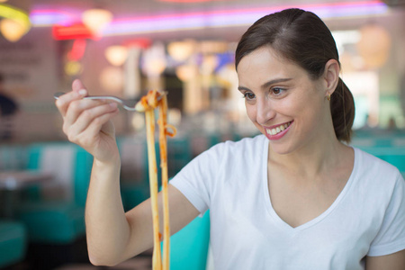 年轻漂亮的女人吃 spaguetti 进美国餐厅