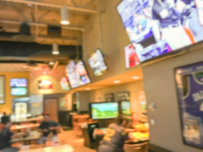 模糊抽象体育酒吧餐馆在美国。弥散人看体育, 喝啤酒, 吃美国菜