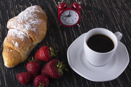 闹钟和草莓 咖啡 羊角面包的早餐