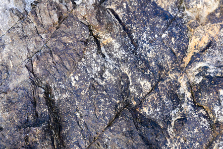 岩石的纹理和表面的背景。裂纹和风化的天然石背景