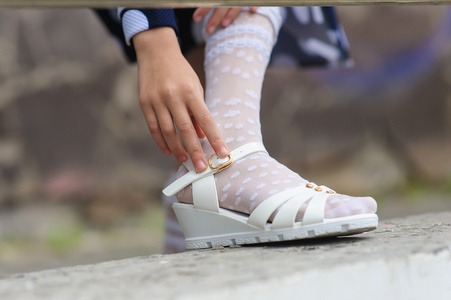 小女孩穿上她的凉鞋照片