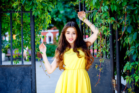在城市街道上在夏天穿着黄色连衣裙的小女孩