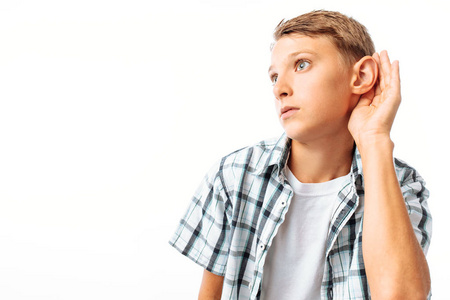 男孩听到, 把他的手, 他的耳朵听到更好的, 在工作室的白色背景照片
