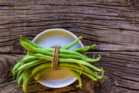绿色四季豆仿古木制的桌子上的碗里