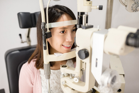 女人做眼试验在光学诊所