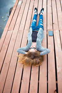 年轻女子躺在码头上