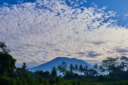 风景如画的风景。日出以上贡火山, 巴厘岛。剪影巴厘岛神圣的山贡的背景下, 清晨的天空与许多云彩。美丽的世界。梦幻般的早晨