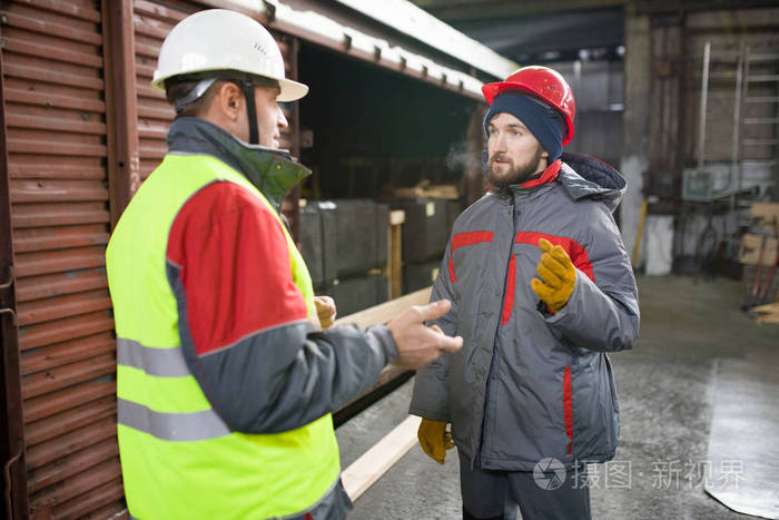 两个穿着安全帽的工人的腰纵向谈现代工业车间的生产, 复制空间