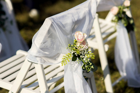为户外婚礼举行的花卉装饰椅。婚纱装饰