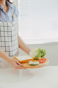 妇女围裙准备在厨房的早餐