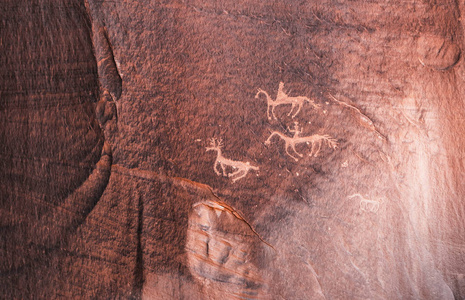 雕刻 Anasazi 岩画在砂岩悬崖代表两个骑马的骑手狩猎与鹿峡谷 de 谢伊国家纪念碑, 亚利桑那州, 美国的动物